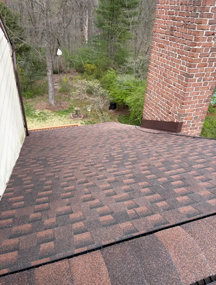 Aerial view of a roof and chimney being inspected and repaired by Quietstorm Exteriors